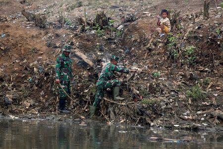 Indonesian soldiers work during a clean-up operation along the Citarum river, south of Bandung, West Java province, Indonesia, February 13, 2018. REUTERS/Darren Whiteside