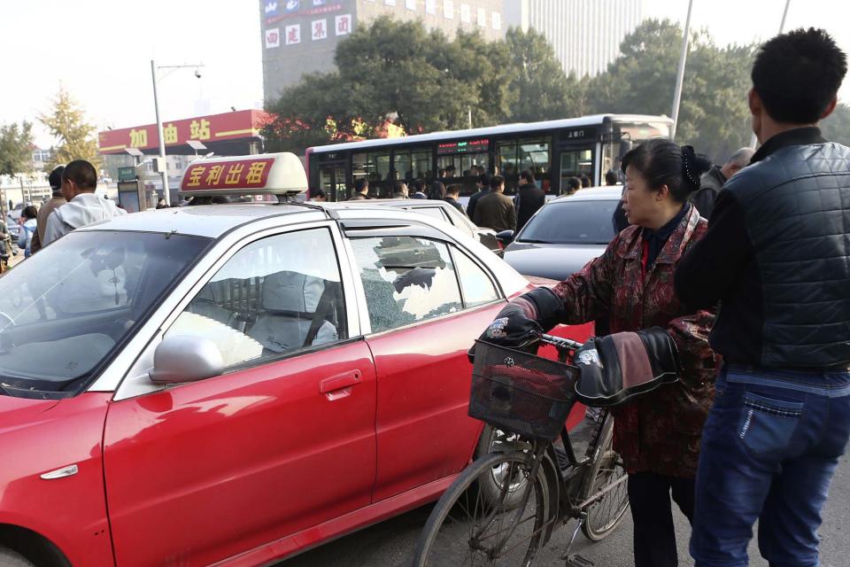 People look at the scene after explosions outside the Shanxi Provincial Communist Party office building in Taiyuan