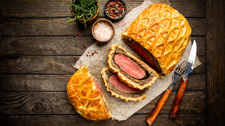 sliced beef wellington on wooden table