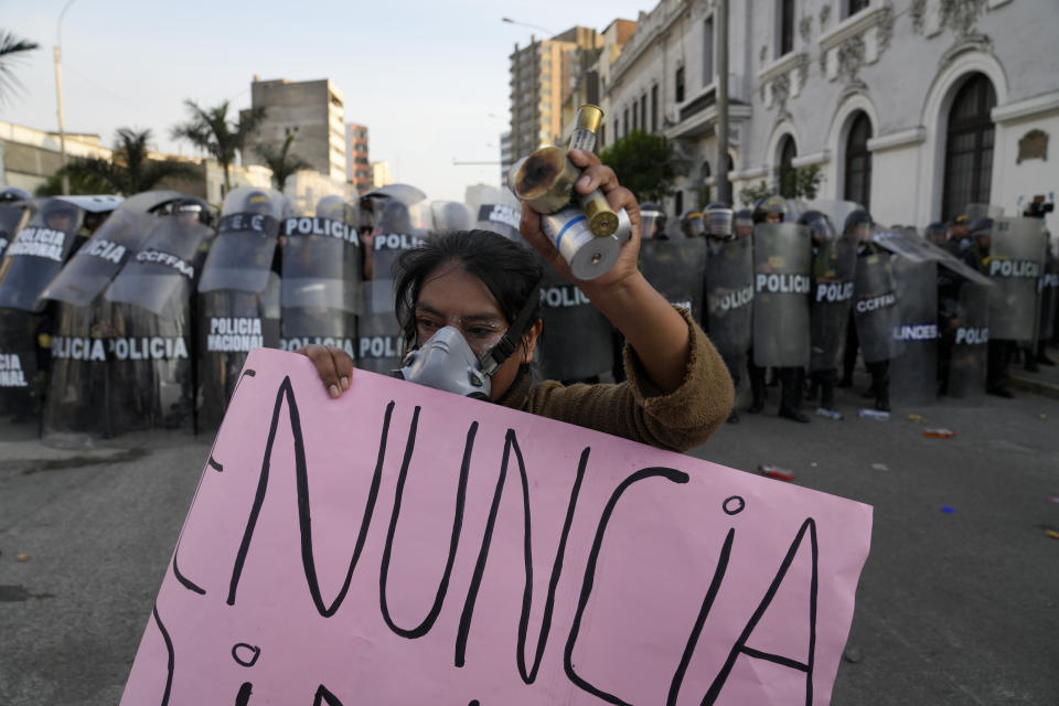 Una mujer muestra los casquillos de una bomba de gas lacrimógeno presuntamente disparadas por la policía y lleva un cartel que pide la renuncia de la presidenta Dina Boluarte en Lima, Perú, el jueves 26 de enero de 2023. Las protestas buscan un adelanto electoral inmediato, la renuncia de Boluarte, la liberación del presidente destituido Pedro Castillo y justicia por los manifestantes muertos en enfrentamientos con la policía. (AP Foto/Martin Mejia)