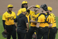 Pittsburgh Pirates pitcher Martín Pérez, third from right, gets a visit from pitching coach Oscar Marin during the sixth inning of a baseball game against the Colorado Rockies in Pittsburgh, Friday, May 3, 2024. (AP Photo/Gene J. Puskar)