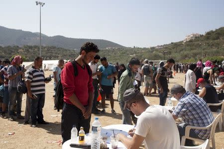 Refugees and migrants register inside a soccer stadium used as a registration centre at the city of Mytilene, on the Greek island of Lesbos, September 8, 2015. REUTERS/Dimitris Michalakis