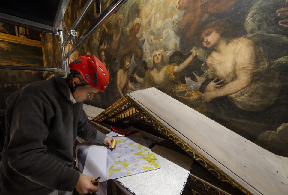 Restorer Alberto Marcon maps signs of decay on the 7,45x24,65-meter oil on canvas 'Il Paradiso' completed in 1592 by Venetian painters Jacopo Robusti, also known as Tintoretto, and his son Domenico in the Maggior Consiglio Hall inside Palazzo Ducale in Venice, northern Italy, Wednesday, Dec. 6, 2022. The Doge's Palace, the heart of the political life of the Venetian Republic for centuries, is undergoing a major reconnaissance of its conservation status by the Fondazione Musei Civici of the municipality of Venice that includes the urgent restoration of its paintings and infrastructures, which is expected to be completed in the summer of 2023. (AP Photo/Domenico Stinellis)