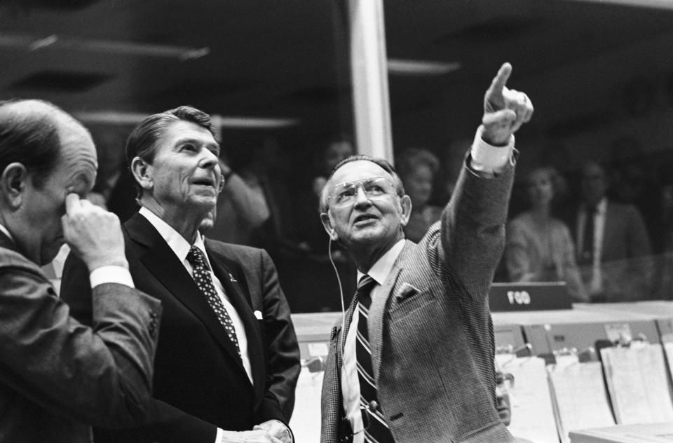 In this 1981 photo, President Ronald Reagan (centre) is briefed by Mr Kraft (right) at the Johnson Space Center in Houston (AP)