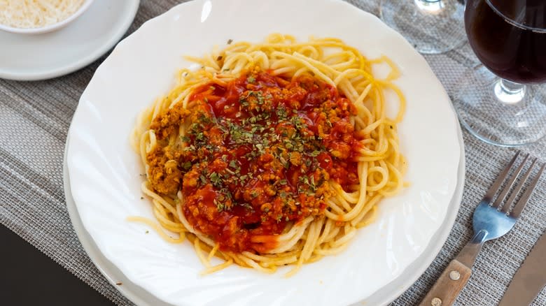 Plated spaghetti Bolognese on a plaid place mat