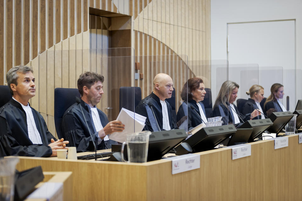 Presiding judge Hendrik Steenhuis, third from left, opens the court session as the trial resumed at the high security court building at Schiphol Airport, near Amsterdam, Monday, June 8, 2020, for three Russians and a Ukrainian charged with crimes including murder for their alleged roles in the shooting down of Malaysia Airlines Flight MH17 over eastern Ukraine nearly six years ago. (AP Photo/Robin van Lonkhuijsen, POOL)