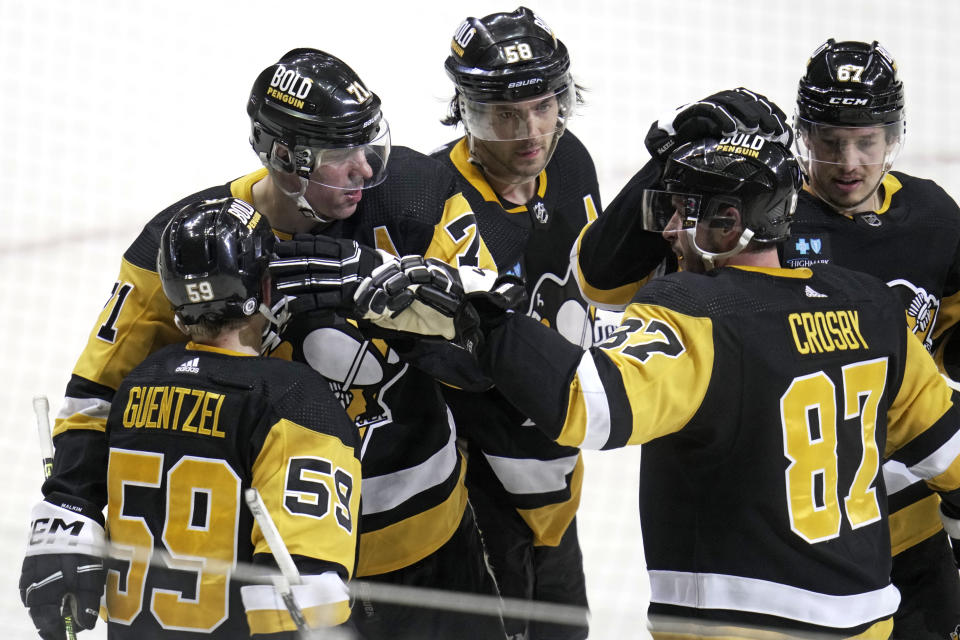Pittsburgh Penguins' Jake Guentzel (59) celebrates with teammates after scoring against the Montreal Canadiens during the second period of an NHL hockey game in Pittsburgh, Tuesday, March 14, 2023. (AP Photo/Gene J. Puskar)