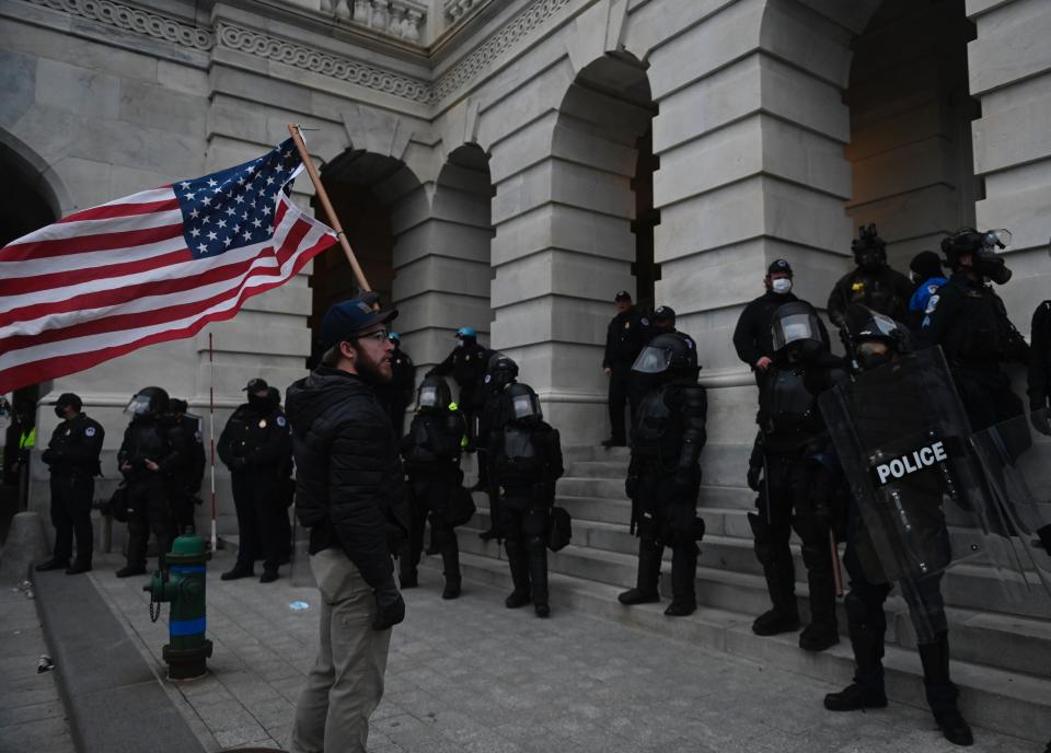 Police look on as a Trump supporter approaches the US CapitolAFP via Getty Images