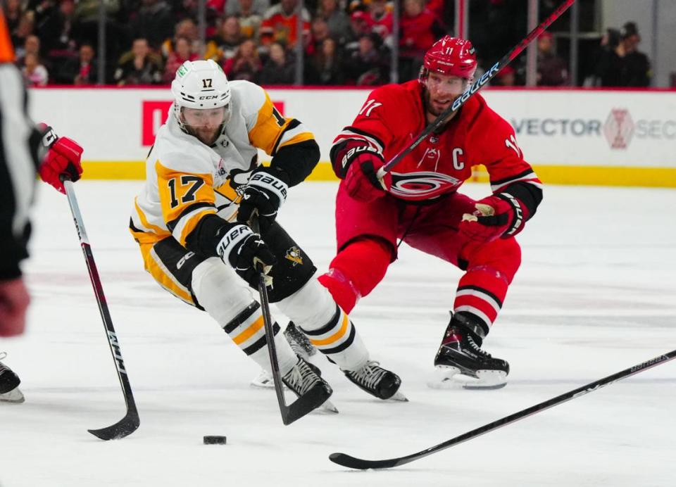 Jan 13, 2024; Raleigh, North Carolina, USA; Pittsburgh Penguins right wing Bryan Rust (17) skates with the puck past Carolina Hurricanes center Jordan Staal (11) during the second period at PNC Arena. Mandatory Credit: James Guillory-USA TODAY Sports
