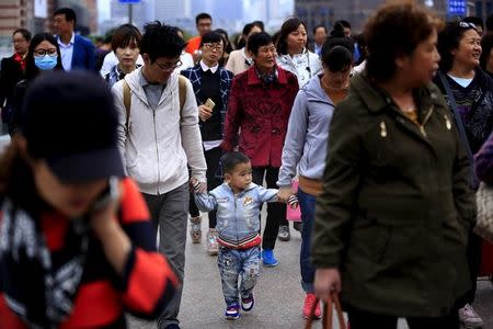 A little boy walks with his parents on a bridge in Shanghai, China, October 30, 2015. REUTERS/Aly Song/Files