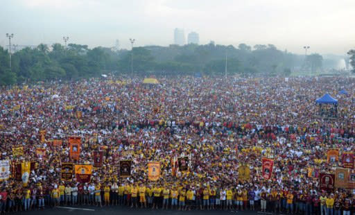 Hundreds of thousands of Philippine Catholic pilgrims attend a mass prior to the start of the annual day-long religious procession in honor of the Black Nazarene, a life-size icon of Jesus Christ carrying a cross, in Manila on January 9, 2012. The "Black Nazarene" march is one of the most spectacular of many religious festivals that feature throughout the year, and police estimated between two and three million people turned up on Monday to be part of the crowd. AFP PHOTO/TED ALJIBE