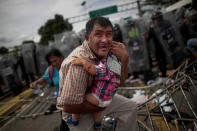 <p>Un inmigrante hondureño protege a su hijo después de que sus compañeros de viaje irrumpieran en un puesto fronterizo entre Guatemala y México y hubiese disturbios.<br>Foto: REUTERS/Ueslei Marcelino </p>