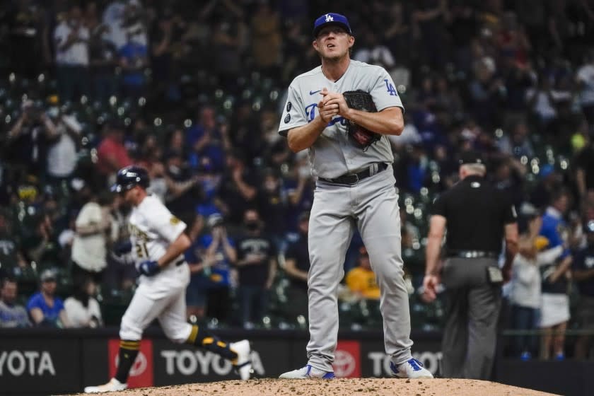 Los Angeles Dodgers' Garrett Cleavinger reacts after giving up a home run to Milwaukee Brewers' Travis Shaw.