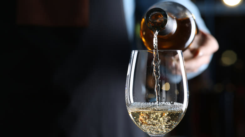 man pouring glass of wine