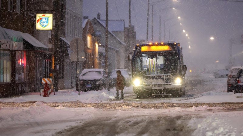 A bus drops off a commuter near the Berwyn Metra stop as a winter storm hits the Chicago area on Friday, Jan. 12, 2024.
