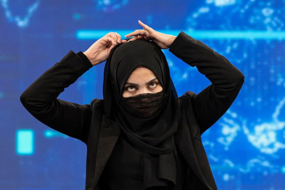 Presenter for TOLOnews, Thamina Usmani, covers her face during a live broadcast (AFP via Getty Images)