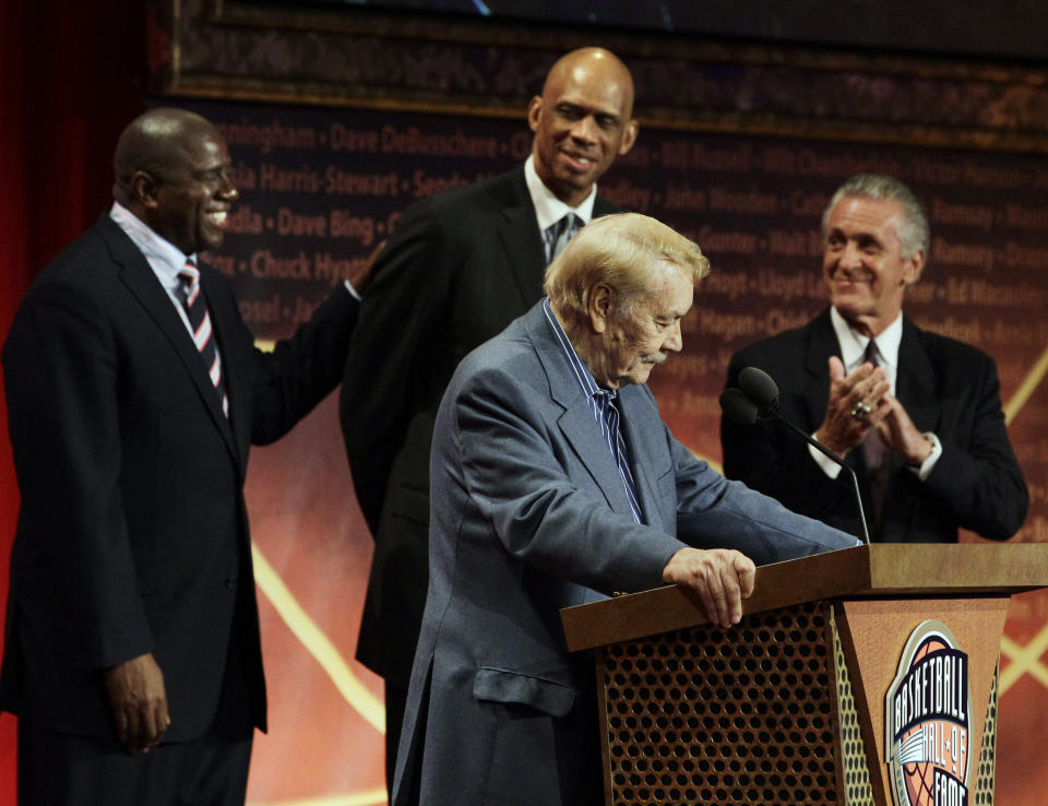 FILE - Basketball Hall of Fame inductee, Los Angeles Lakers owner Jerry Buss, foreground, speaks as, from background left to right, Magic Johnson, Kareem Abdul Jabbar and Pat Riley react during the enshrinement ceremony in Springfield, Mass., Friday, Aug. 13, 2010. Kareem Abdul-Jabbar's reign atop the NBA career scoring list is about to end after nearly four decades. LeBron James is on the verge of passing Abdul-Jabbar for the record that he's held since 1984.(AP Photo/Elise Amendola, File)