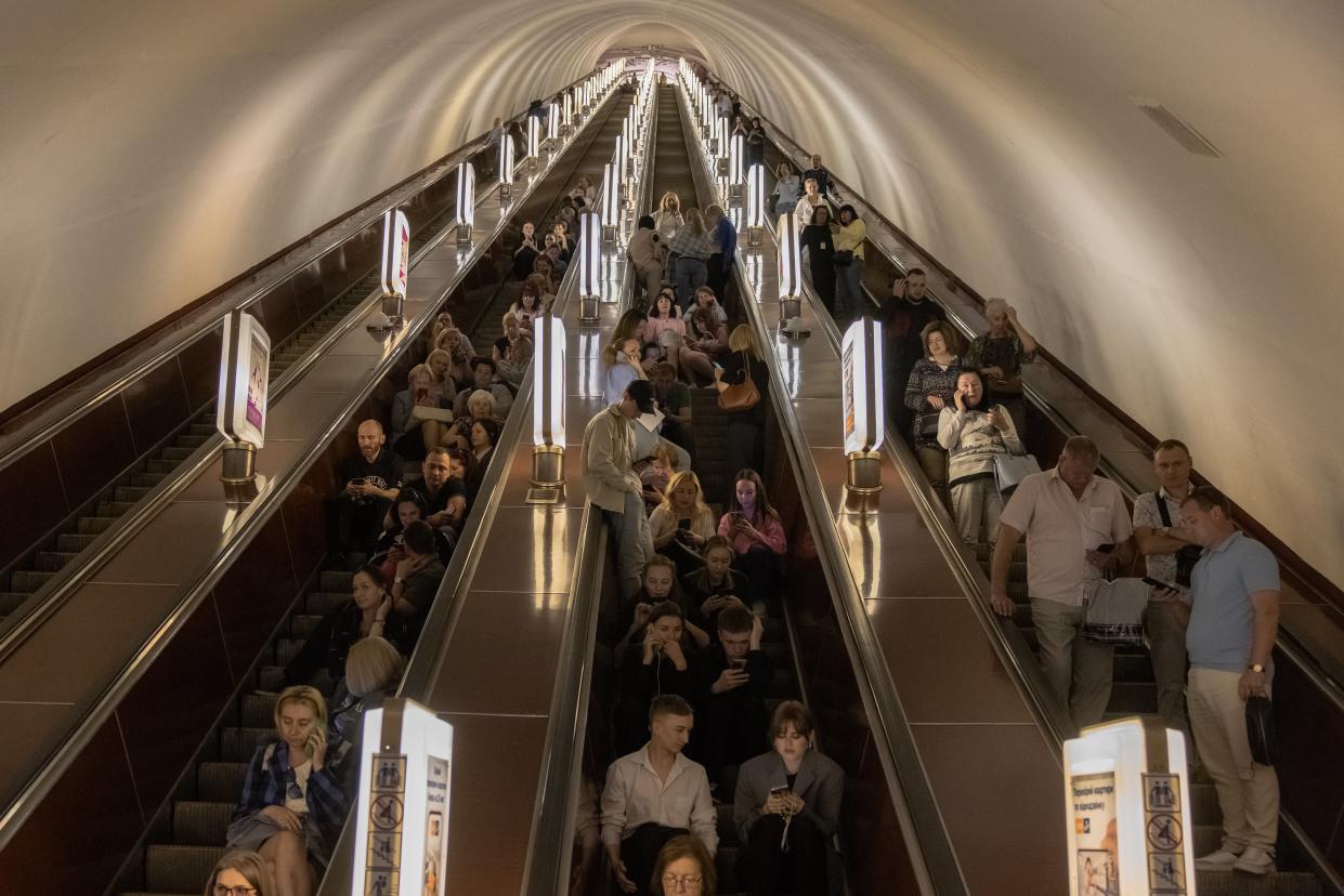 People sit on an escalator as they shelter in a Kyiv subway station during Russian missiles attack on 29 May (Getty Images)