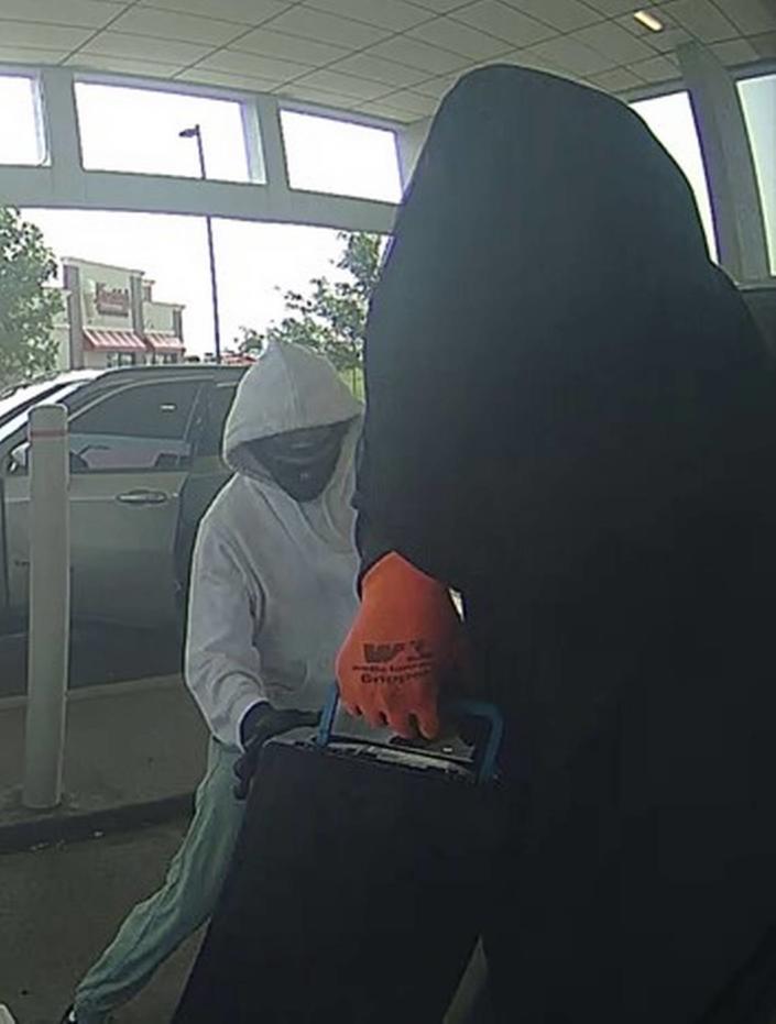 Two masked men approached a victim “working on” an ATM and fled with cash, according to the FBI.