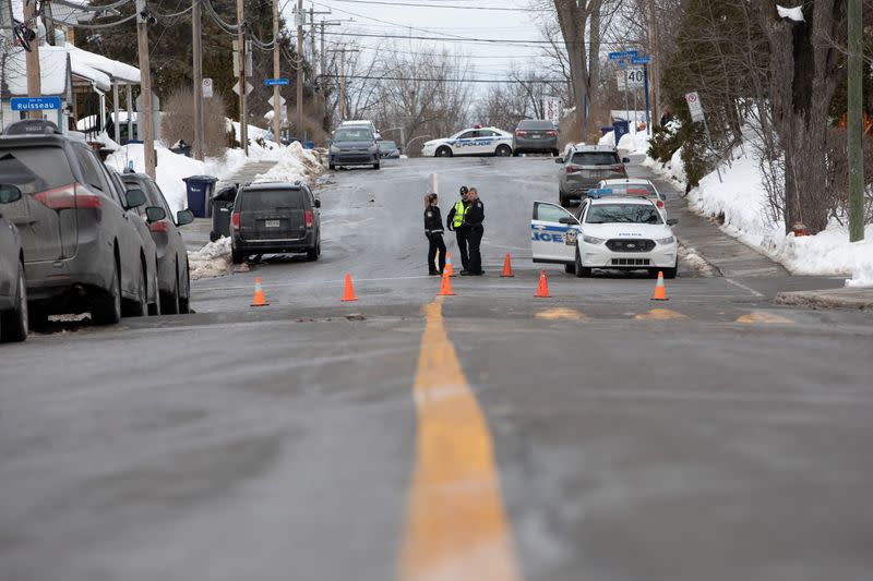 Laval police officers stand on patrol at a road block on Dufferin Terrace