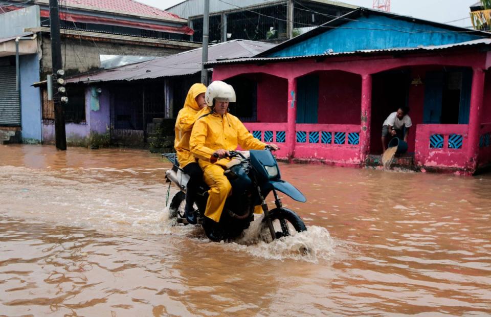 People ride a motorbike through flooded streets in Bluefields, Nicaragua on Sunday (AFP via Getty Images)