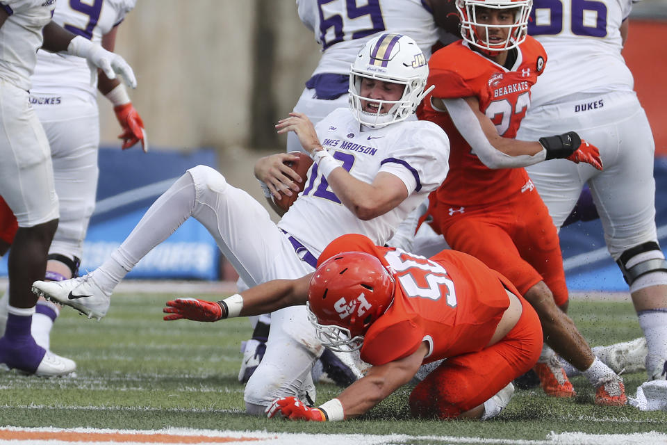 James Madison quarterback Cole Johnson (12) is sacked by Sam Houston State linebacker Ysidro Mascorro (50) during the fourth quarter of a semifinal game in the NCAA college football FCS playoffs, Saturday, May 8, 2021, in Huntsville, Texas. Sam Houston came from behind to edge James Madison 38-35, for a berth in the FCS national championship game. (Brett Coomer/Houston Chronicle via AP)