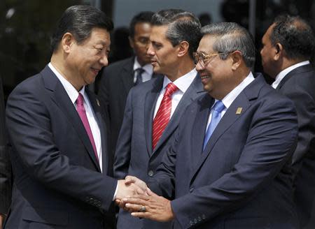 China's President Xi Jinping (L) shakes hands with Indonesia's President Susilo Bambang Yudhoyono, in front of Mexico's President Enrique Pena Nieto (C), as they walk to their venue for the Asia-Pacific Economic Cooperation (APEC) Summit family photo in Nusa Dua on the Indonesian resort island of Bali October 8, 2013. REUTERS/Beawiharta