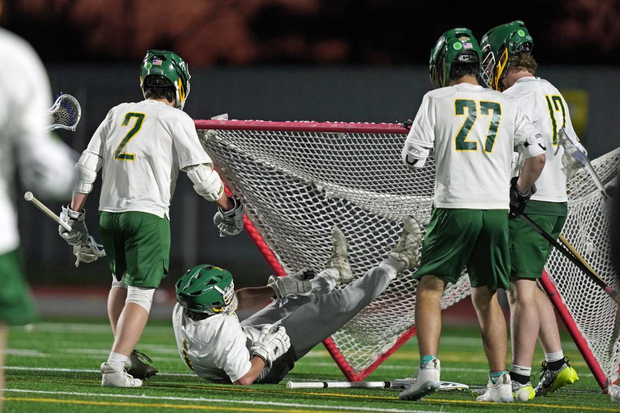 Smithfield goalie Dalton Donoyan (bottom) pulls the net down in celebration as teammates rush in to join him following the Sentinels' win over Westerly on Thursday night.