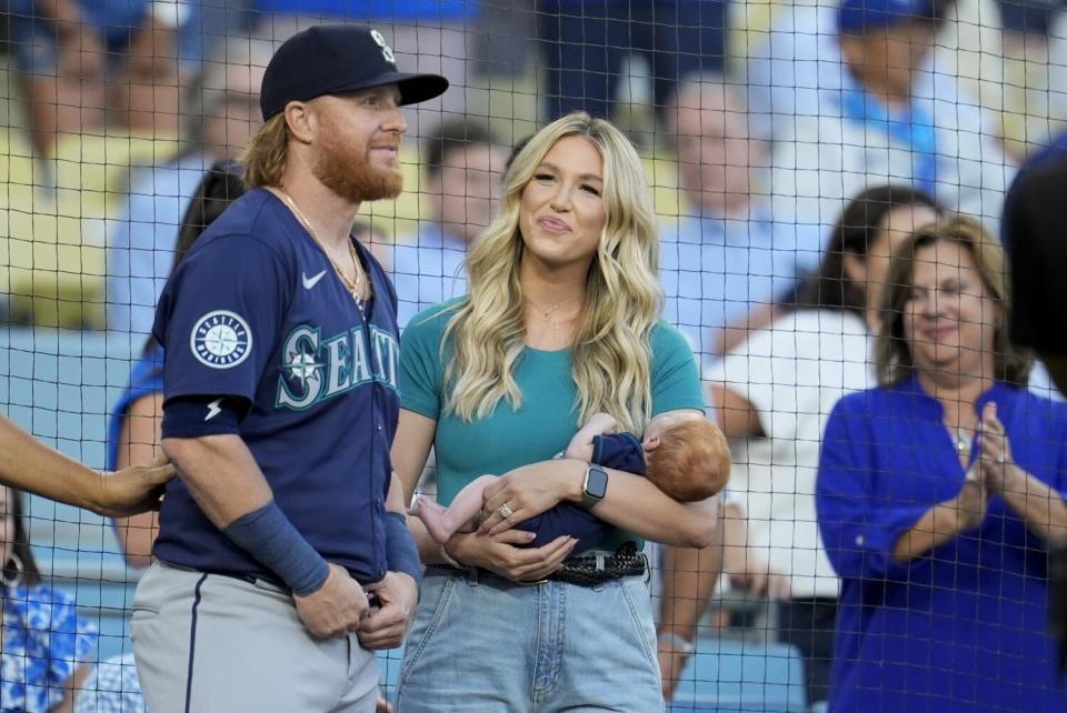 Seattle's Justin Turner (left) stands next to his wife Kourtney and their son Bo as he is honored.