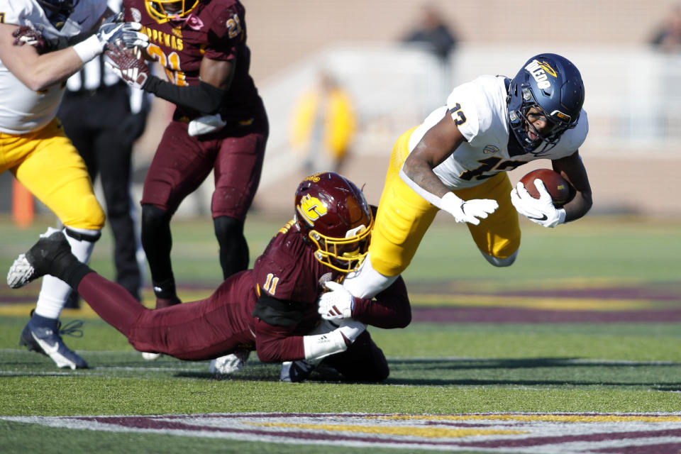 Toledo running back Peny Boone, right is tackled by Central Michigan linebacker Dakota Cochran (11) during the first half of an NCAA college football game, Friday, Nov. 24, 2023, in Mount Pleasant, Mich. (AP Photo/Al Goldis)