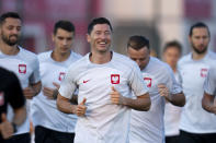 Poland's Robert Lewandowski, center, works out with teammates during a training session in Doha, Qatar, Saturday, Dec. 3, 2022. Poland will play against France in the round of 16 phase of the World Cup soccer tournament on Dec. 4. (AP Photo/Julio Cortez)