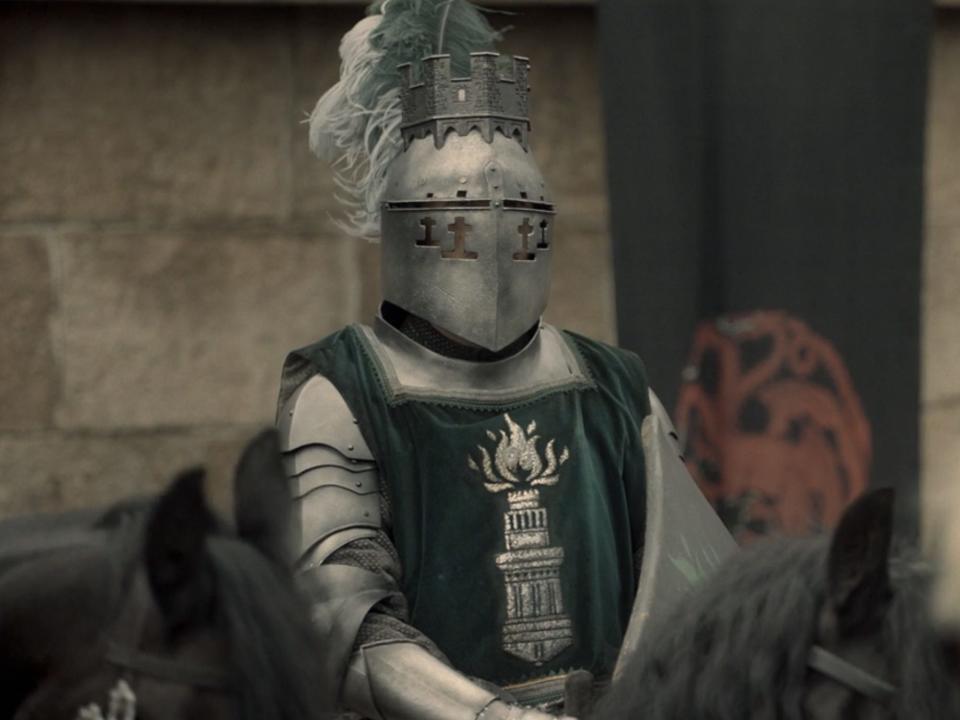 A knight with a green tunic showing a tower sigil.