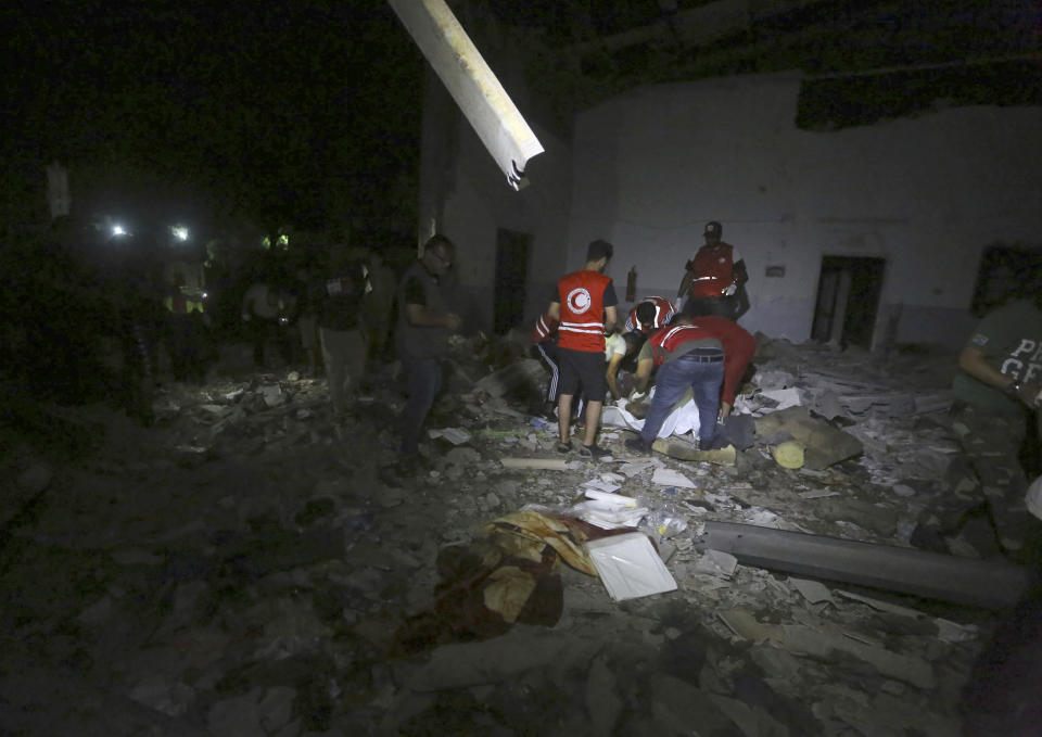 Libyan Red Crescent workers recover migrants bodies after an airstrike at a detention center in Tajoura, east of Tripoli Wednesday, July 3, 2019. An airstrike hit the detention center for migrants early Wednesday in the Libyan capital. (AP Photo/Hazem Ahmed)
