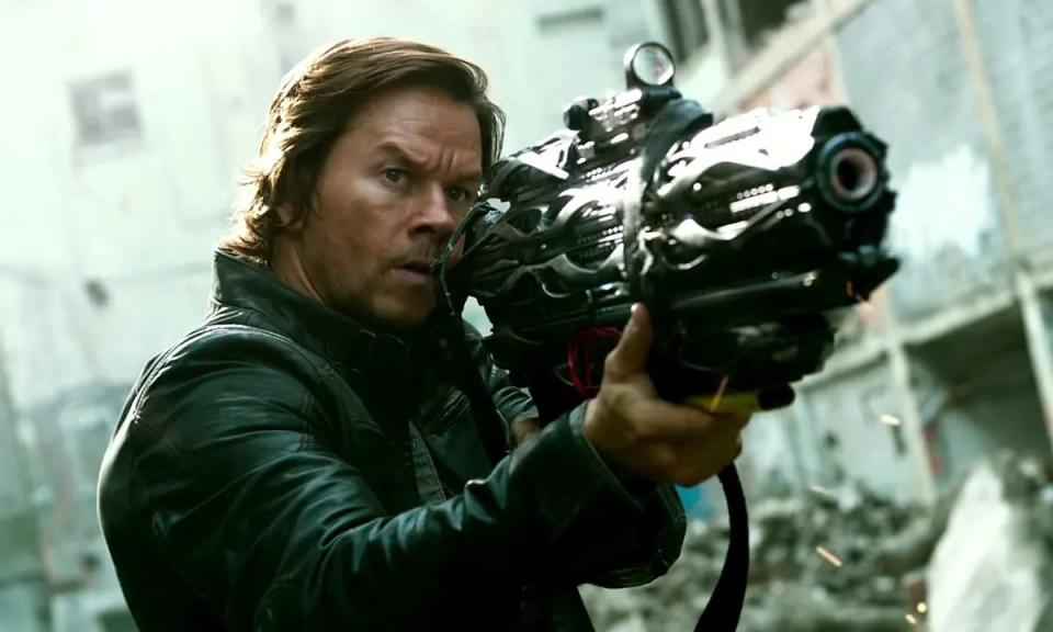 cade yaeger, played by mark wahlberg, holds a gun in a scene from transformers the last knight