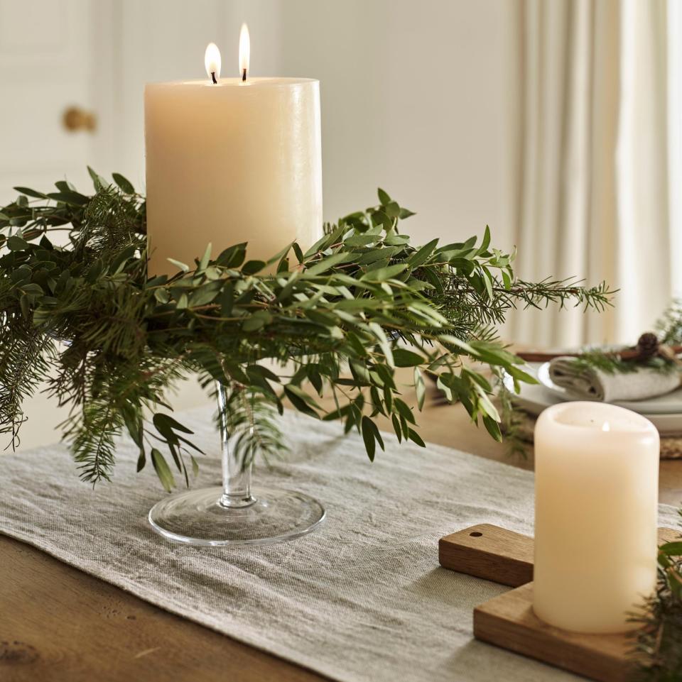 For an extra-festive touch, lay a simple wreath flat on the kitchen island and fill it with tall pillar candles - Chris Everard