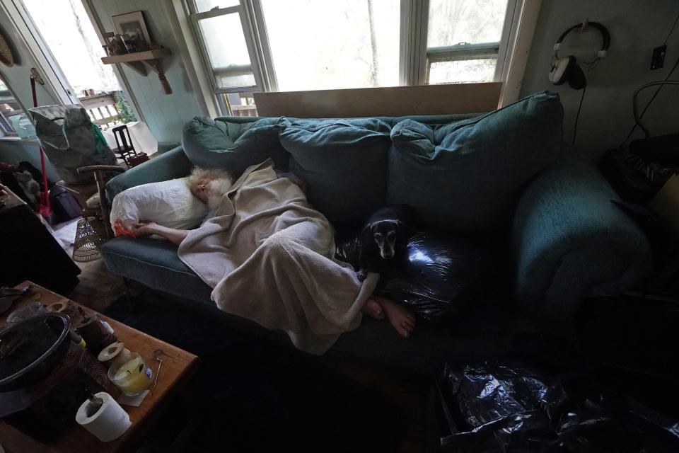 Dirk Russell, who has medical issues, lies on the sofa in his waterlogged home that flooded in the aftermath of Hurricane Ian on Pine Island, Fla., Saturday, Oct. 1, 2022. The only bridge to the island is heavily damaged so it can only be reached by boat or air. (AP Photo/Gerald Herbert)