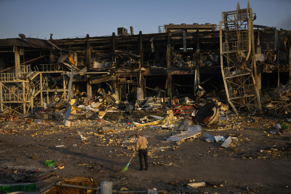 Un hombre barre escombros junto a un centro comercial y de entretenimiento el viernes 13 de mayo de 2022 en Odesa, Ucrania, destruido el 9 de mayo por un ataque de misiles rusos. (AP Foto/Francisco Seco)