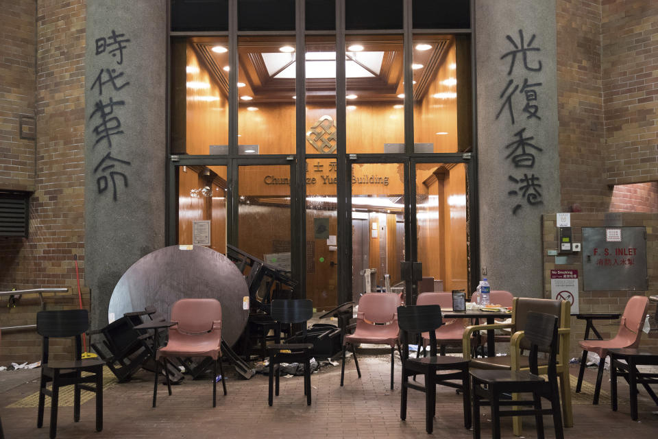 This Friday, Nov. 22, 2019, photo, shows the broken glass doors at one of the buildings of the Hong Kong Polytechnic University campus in Hong Kong. Most of the protesters who took over the university have left following clashes with police, but an unknown number have remained inside, hoping somehow to avoid arrest. (AP Photo/Vincent Thian)