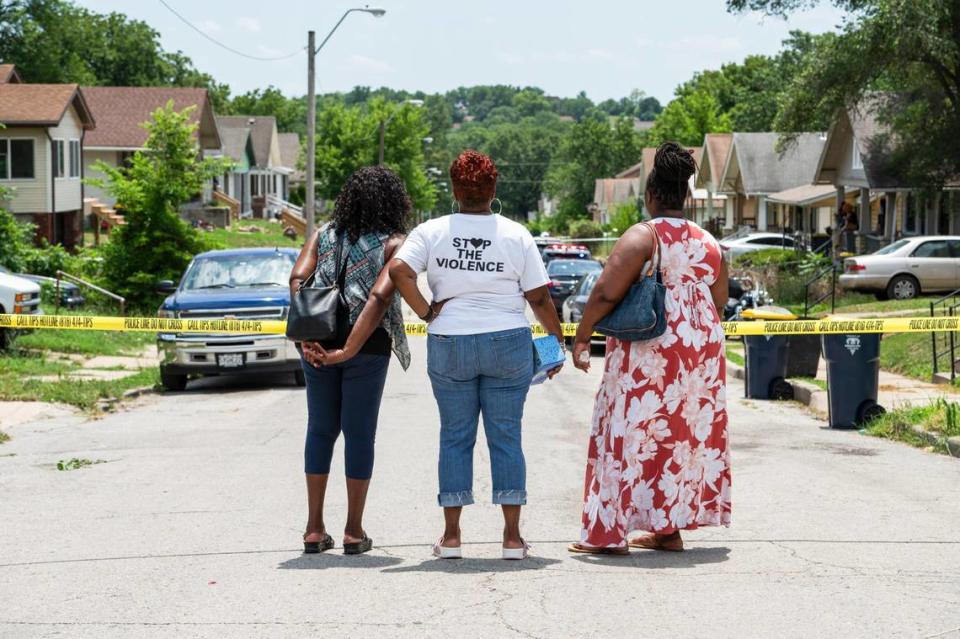 Founder and director of Kansas City Mothers in Charge, Rosilyn Temple, middle, looks over the scene of a fatal shooting that left one person dead on the 4500 block of South Benton Avenue on July 12 in Kansas City.