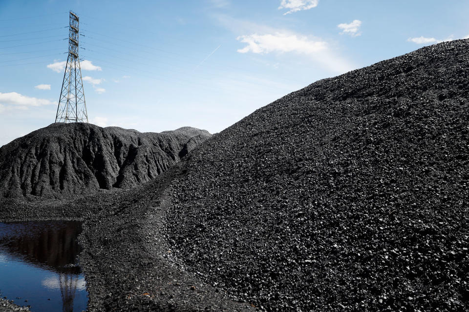 <p>Piles of coal rest at a facility along the Ohio River as power transmission lines stand in the background, Friday, April 7, 2017, in Cincinnati, Ohio. (AP Photo/John Minchillo) </p>