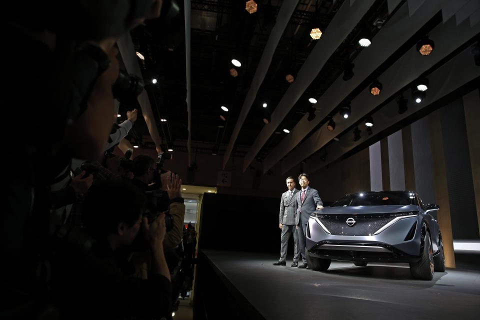 Alfonso Albaisa, left, senior vice president for Global Design for Nissan Motor Corp., and Kunio Nakaguro, executive vice president, pose for photos during Nissan's presentation of the media preview of the Tokyo Motor Show Wednesday, Oct. 23, 2019, in Tokyo. (AP Photo/Kiichiro Sato)