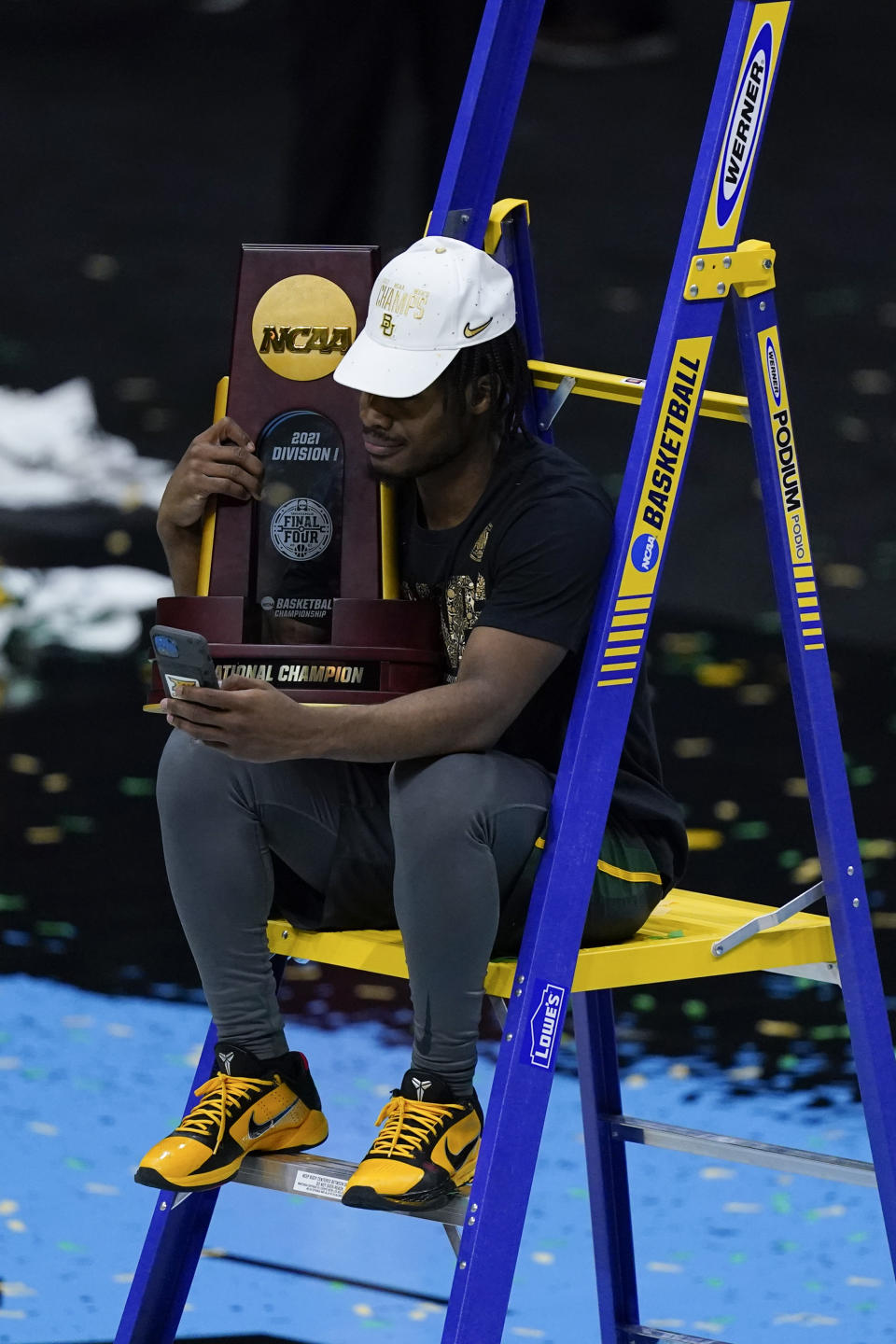 Baylor guard Davion Mitchell (45) sits with the trophy after the championship game against Gonzaga in the men's Final Four NCAA college basketball tournament, Monday, April 5, 2021, at Lucas Oil Stadium in Indianapolis. Baylor won 86-70. (AP Photo/Michael Conroy)