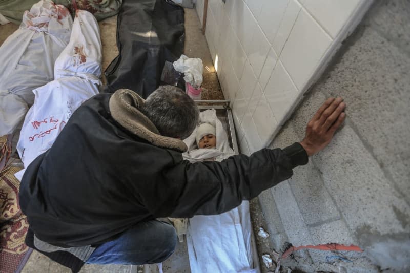 A man griefs next to the dead bodies of Palestinians at Al-Aqsa Martyrs Hospital in Deir Al-Balah, following an Israeli attack on an entire residential neighbourhood in the Nuseirat. Mohammed Talatene/dpa