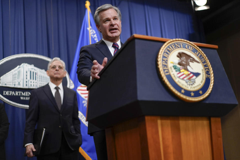 Attorney General Merrick Garland, left, listens as FBI Director Christopher Wray speaks at the Department of Justice in Washington, Friday, Jan. 27, 2023, to discuss recent law enforcement action in transnational security threats case. (AP Photo/Carolyn Kaster)