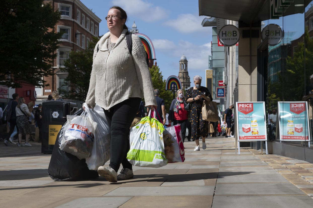 A woman carrying multiple bags of shopping up the city's main commercial street in Manchester, England. Photo: Daniel Harvey Gonzalez/In Pictures via Getty Images