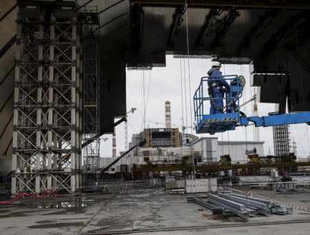 An employee works on the New Safe Confinement (NSC) structure at the site of the Chernobyl nuclear power plant, Ukraine, March 23, 2016. REUTERS/Gleb Garanich