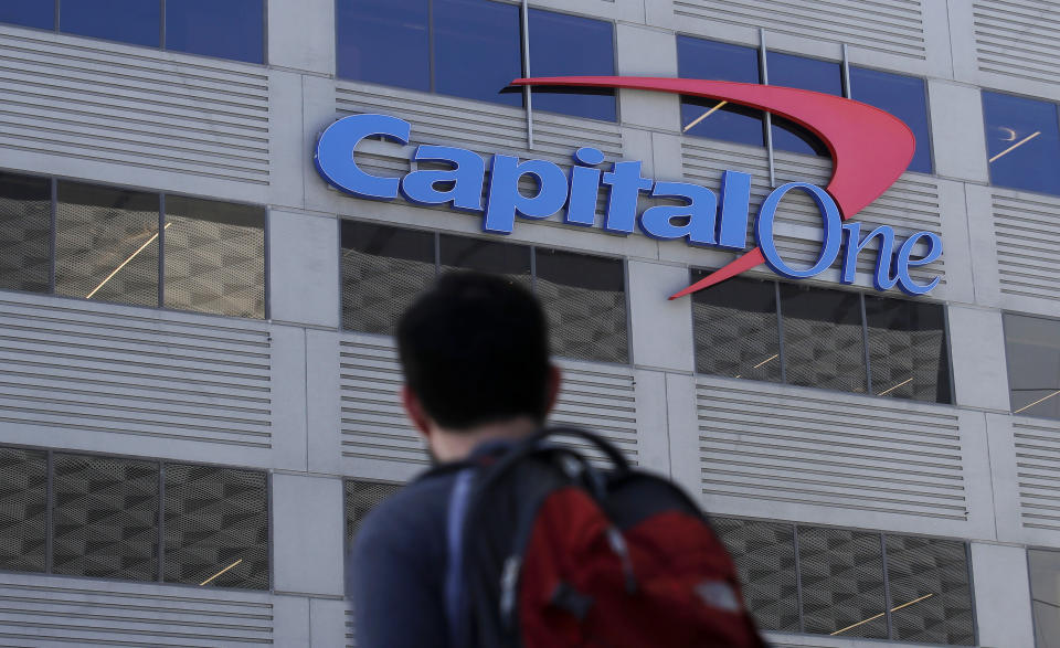 FILE - In this July 16, 2019, file photo, a man walks across the street from a Capital One location in San Francisco. A security breach at Capital One Financial, one of the nation's largest issuers of credit cards, compromised the personal information of about 106 million people, and in some cases the hacker obtained Social Security and bank account numbers. (AP Photo/Jeff Chiu, File)