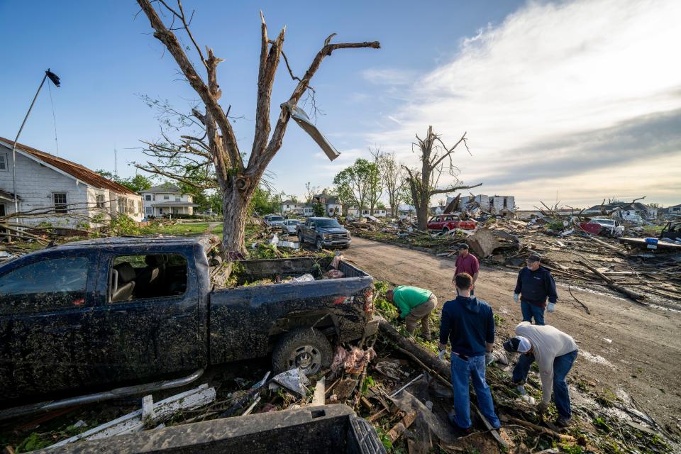 Friends and family help Randy Hennigar clean up debris from outside his home in Greenfield, Wednesday, May 22, 2024. Multiple residents were killed when a tornado struck the town Tuesday afternoon.