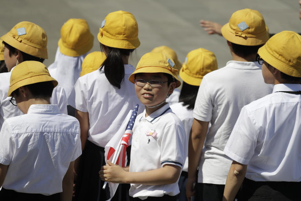 School children wait for President Donald Trump and first lady Melania Trump to arrive participate in a welcome ceremony at the Imperial Palace, Monday, May 27, 2019, in Tokyo. (AP Photo/Evan Vucci)
