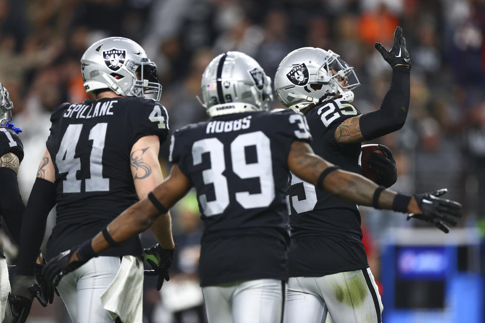 Las Vegas Raiders safety Tre'von Moehrig (25) celebrates his interception with linebacker Robert Spillane (41) and cornerback Nate Hobbs (39) during the second half of an NFL football game against the Denver Broncos, Sunday, Jan. 7, 2024 in Las Vegas. The Raiders won 27-14. (AP Photo/Ellen Schmidt)